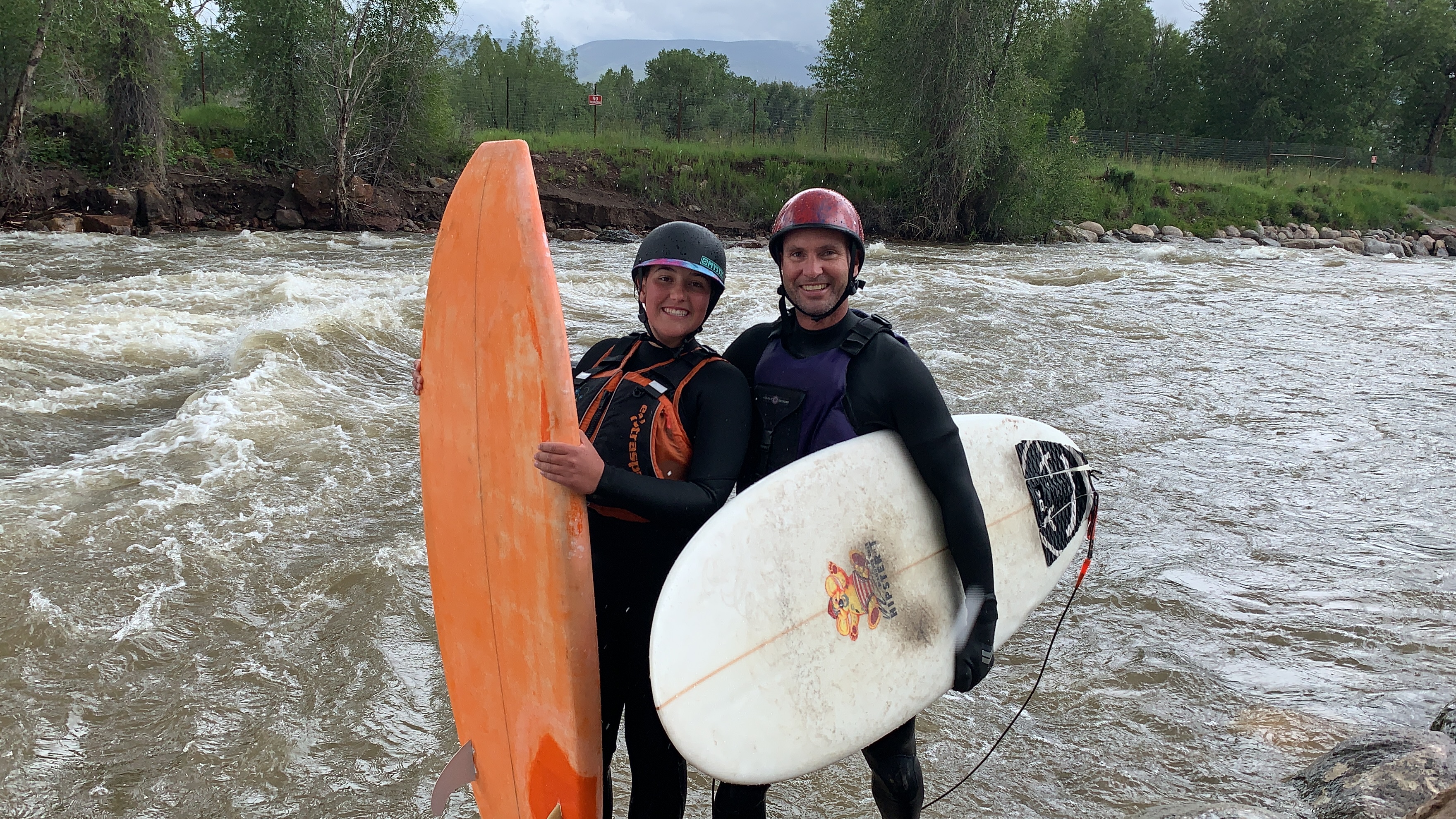 Two river surfers with their boards by the Eagle River